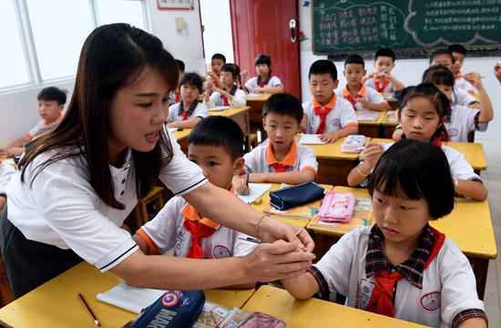 9月10日,福建省邵武市东关小学教师傅凤英在近视防控课上指导学生握笔正姿。新华社记者 彭张青/摄