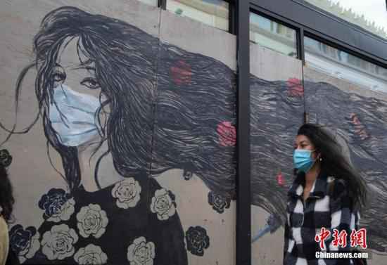 当地时间11月21日,美国加州旧金山市民戴口罩出行。中新社记者 刘关关 摄