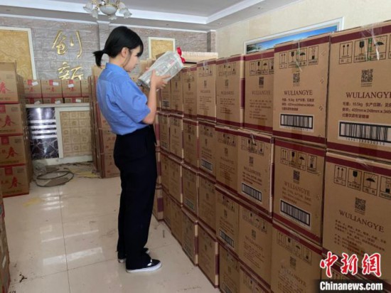 资料图为检察人员核对查获的假冒品牌白酒。 青海省人民检察院供图